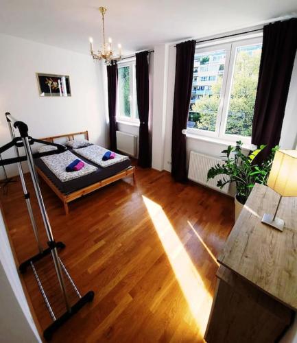 ein Wohnzimmer mit einem Bett und zwei Fenstern in der Unterkunft Art of Simmering in Wien