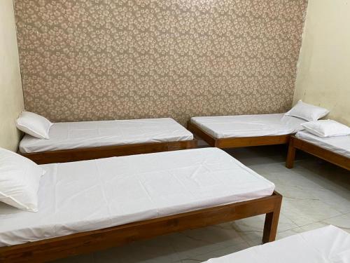 - un groupe de trois lits dans une chambre dans l'établissement Hotel Virat Palace, à Daryābād