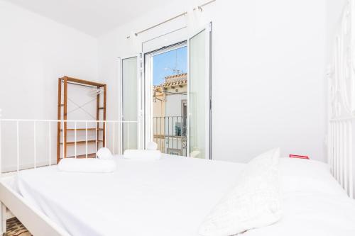 Dormitorio blanco con espejo grande y cama en HomeHolidaysRentals Arlene, en Calella