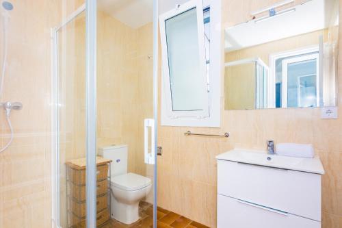 a bathroom with a toilet and a sink and a mirror at HomeHolidaysRentals Arlene in Calella