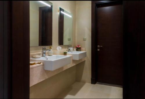 a bathroom with two sinks and a large mirror at Villa in Al Madinah in compound فيلا في المدينة in Al Madinah