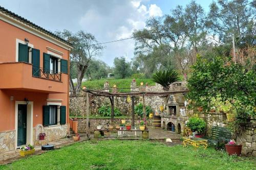 a backyard with a stone wall and a house at Nature retreat apartment in Kalafatiónes