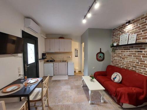 a living room with a red couch and a kitchen at Nature retreat apartment in Kalafatiónes