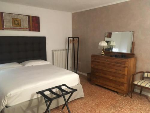 a bedroom with a bed and a dresser and a mirror at Bottega de la Sminca in Negrar