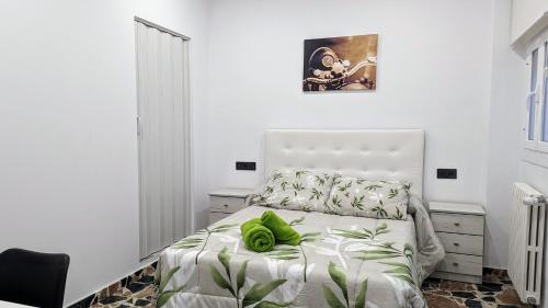 biała sypialnia z zieloną poduszką na łóżku w obiekcie Casa Clari w mieście Motilla del Palancar