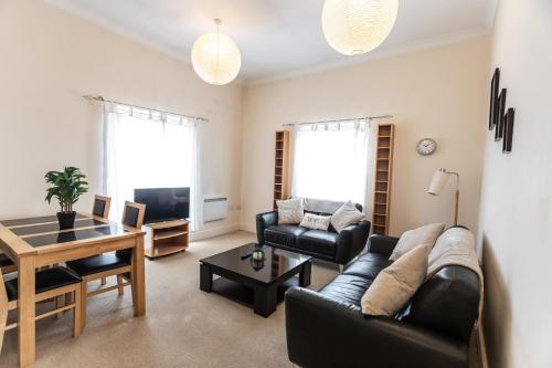 a living room with a couch and a table at April Disc - Long Stay - Contractors in Swindon