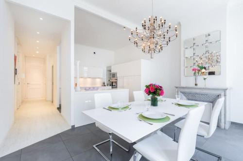 une salle à manger blanche avec une table et des chaises blanches dans l'établissement 5-Star Apartment on Rue d’Antibes, à Cannes