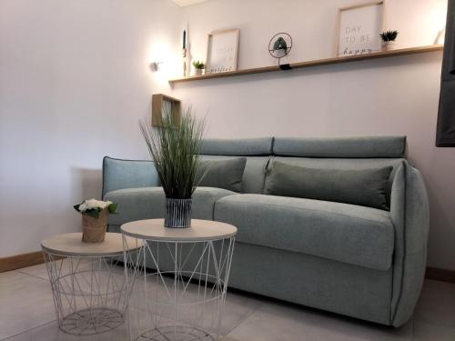 un soggiorno con un divano e due tavoli di -Studio Aix les bains face au lac- ad Aix-les-Bains