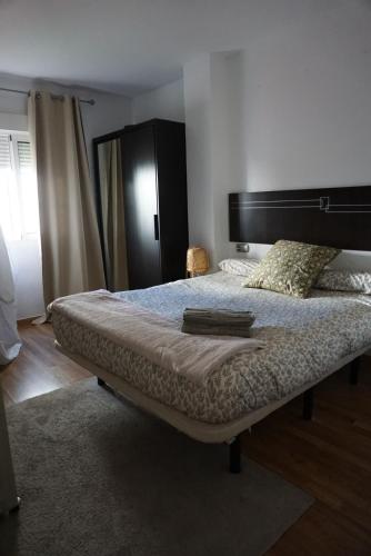 una camera da letto con un grande letto con una grande testiera di Apartamento en Huelva. a Huelva