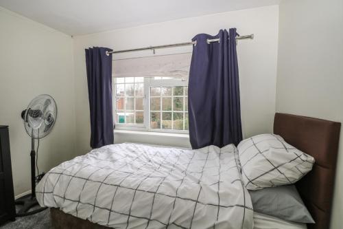 2A Kent Cottages في ريدينغ: غرفة نوم بسرير ونافذة