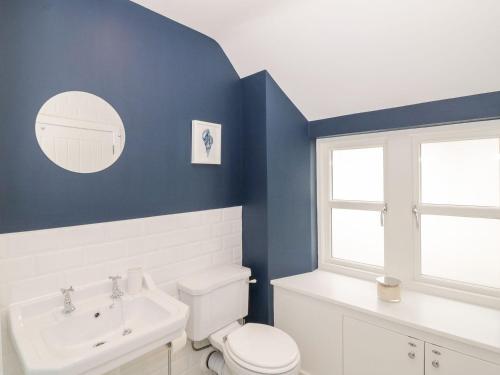 a bathroom with a white toilet and a sink at Harts Cottage in Kirkcudbright