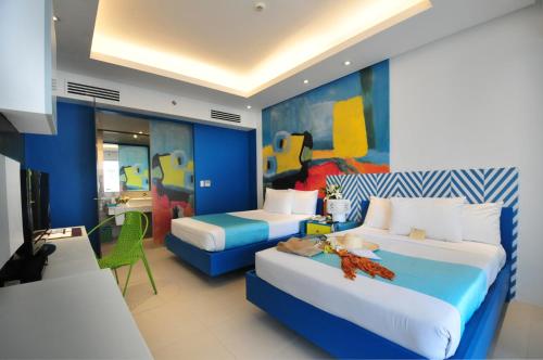 
a room with a bed, a desk, and a painting on the wall at Astoria Current in Boracay
