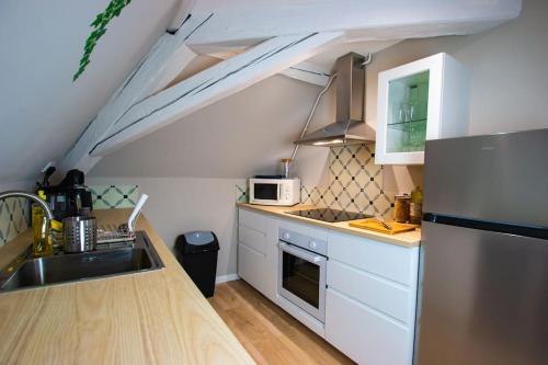 una cucina con lavandino e piano cottura forno superiore di Au coeur du vignoble/centre ville a Dorlisheim