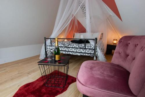 sala de estar con silla morada y cama en Au coeur du vignoble/centre ville, en Dorlisheim