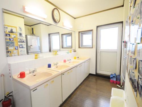 稚内市にあるペンション亜留芽利亜のバスルーム(洗面台2台、壁掛け時計付)