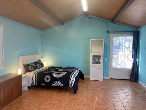 1 dormitorio con 1 cama en una habitación con paredes azules en La Geneta Casa Vacacional, en Vilobí del Penedès