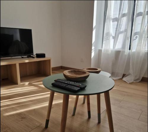 a living room with a table with a remote control on it at Spacieux Studio in Mer