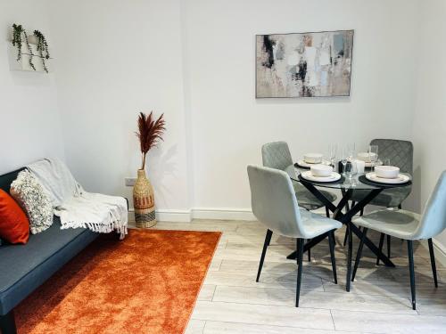 a dining room with a black table and chairs at Delightful Ealing Retreat - Steps to Tube & Shops in Ealing