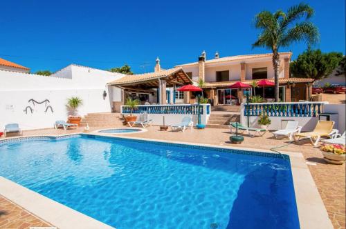 a swimming pool in front of a house at Quinta Jardim das Palmeiras, T2 n 8 , Algoz in Silves