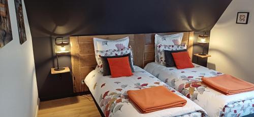 2 Einzelbetten in einem Zimmer mit 2 Lampen in der Unterkunft Maison d'Hôtes "L'ORIGINALE" in Niederbronn