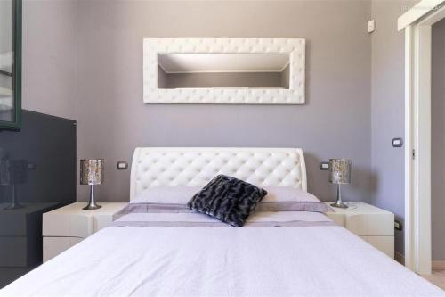 een slaapkamer met een wit bed met een wit hoofdeinde bij Villino Letizia in Nardò