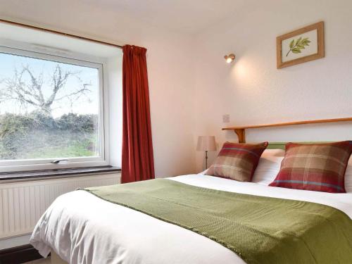 a bedroom with a bed and a large window at Ash Cottage- Uk45892 in Farlam
