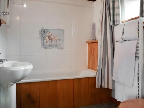 a bathroom with a bath tub and a sink at The Old Dairy - Meadowbrook Farm in Thame