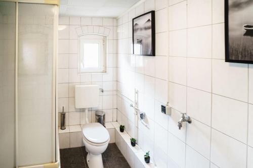 伊本比倫的住宿－B23 Monteure I Teams I 3-Zimmer I Netflix I Premiumbettwäsche I zentral，白色的浴室设有卫生间和窗户。