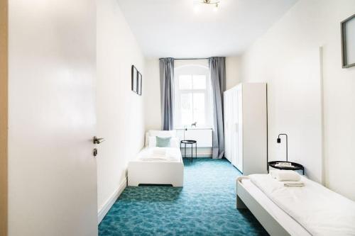 伊本比倫的住宿－B23 Monteure I Teams I 3-Zimmer I Netflix I Premiumbettwäsche I zentral，酒店客房,设有两张床,铺有蓝色地毯。
