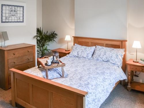 a bedroom with a bed with a nightstand and a table at Pitmans Cottage in Ryton