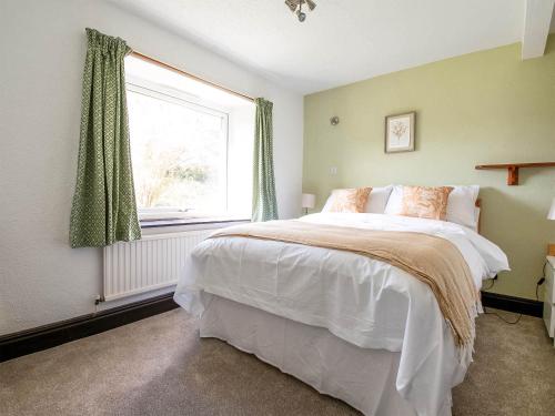 Un dormitorio con una cama grande y una ventana en Alder Cottage - Uk46154, en Farlam