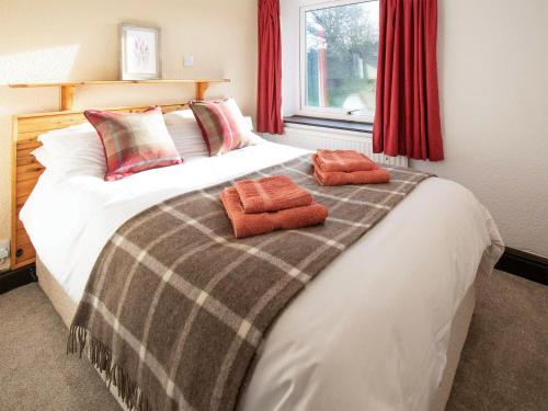 a bedroom with a bed with two towels on it at Bracken Cottage - Uk46155 in Farlam