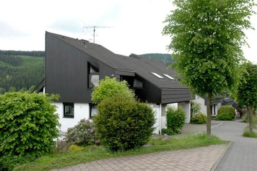 uma casa com um telhado preto em Privatwohnung mit Terrasse zum Relaxen em Lennestadt