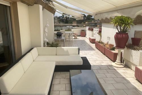 a living room with a couch on a patio at top floor apartment with private park in Montpellier