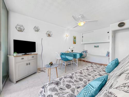 une chambre avec un lit, une table et une télévision dans l'établissement Charme Marin à Leucate, à Leucate