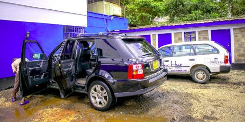 una persona que abre la puerta de un coche en Blue Hut Hotel en Nairobi