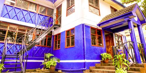 a blue and white house with a purple door at Blue Hut Hotel in Nairobi