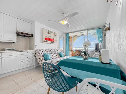 une chambre avec un lit bleu et une cuisine dans l'établissement Charme Marin à Leucate, à Leucate