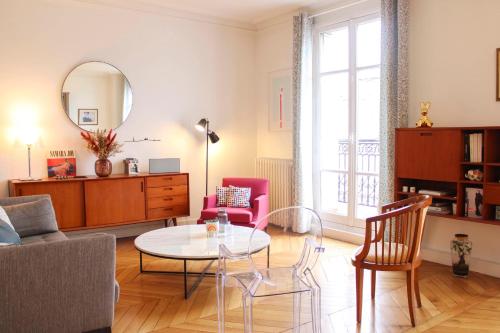 a living room with a table and chairs at Walk-through apartment - near Sacré-Cœur in Paris