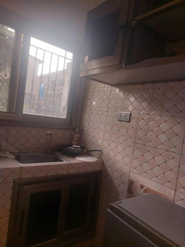 una pequeña cocina con fregadero y ventana en Castor, en Ziguinchor
