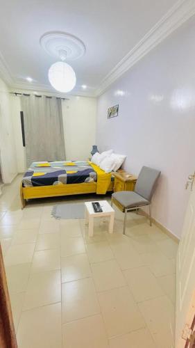a bedroom with a bed and a chair and a table at Castor in Ziguinchor