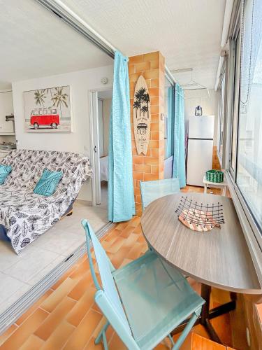un salon avec une table et des chaises et un lit dans l'établissement Charme Marin à Leucate, à Leucate