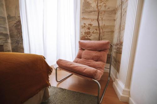 a chair sitting in a room with a bedroom at House Sao Bento in Lisbon