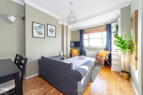 a bedroom with a bed and a table and a desk at Bright and Cosy Apartment in South London in London