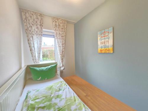 a small bedroom with a bed and a window at Ferienhaus Seemann in Norddeich