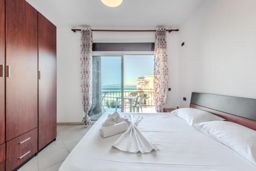 um quarto com uma grande cama branca e uma grande janela em Coastal Comfort by Premium Selection em Durrës