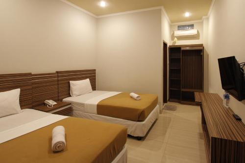 Tempat tidur dalam kamar di Palapa Hotel