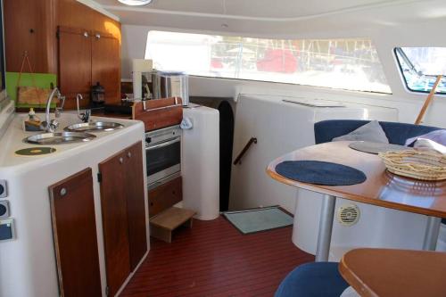 a kitchen with a sink and a table in a boat at Beau catamaran à la marina in Le Marin