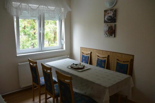 een eetkamer met een tafel en stoelen en een raam bij Béri Apartman in Siófok