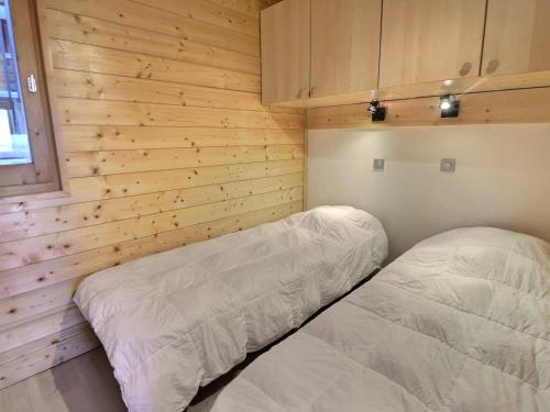 - une chambre avec 2 lits dans un mur en bois dans l'établissement Appartement 2 Pièces, Ski aux Pieds, Proche Commerces, Wi-Fi Gratuit, Animaux Admis - FR-1-182-195, à Les Allues